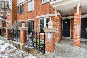 Oakville (Ro River Oaks) townhouse for rent - A red brick house with a black door and a bicycle leaning against the fence.