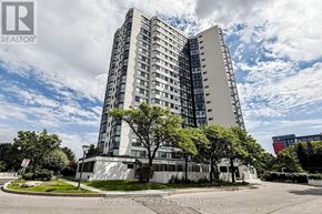 Mississauga (Rathwood) condo for rent - A tall white building with a glass facade stands in front of a blue sky with clouds.
