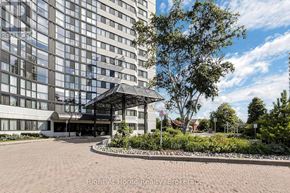 Mississauga (Rathwood) condo for rent - A large building with a glass facade and a tree in front of it.