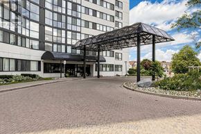 Mississauga (Rathwood) condo for rent - A large building with a glass facade and a black awning.
