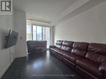 Toronto (Mount Pleasant West) condo for rent - A living room with a brown leather couch and a flat screen TV mounted on the wall.