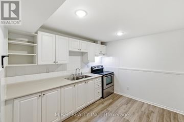 Pickering (Brock Ridge) apartment for rent - A kitchen with white cabinets and a stove top oven.
