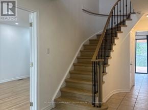 Barrie (Grove East) apartment for rent - A staircase with a wooden handrail and beige steps.