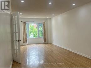 Barrie (Grove East) apartment for rent - A room with wooden flooring and a sliding glass door leading to a garden.