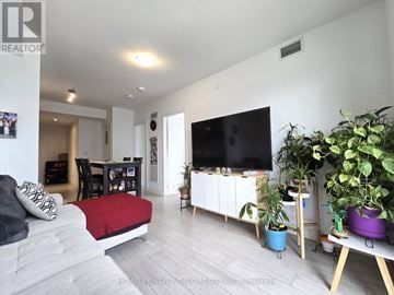 Toronto (Agincourt South-Malvern West) condo for rent - A living room with a grey couch and a red pillow.