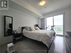 Toronto (Agincourt South-Malvern West) condo for rent - A bedroom with a large bed and a view of the outdoors through a sliding glass door.