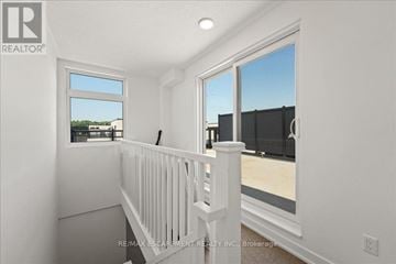 Burlington (Lasalle) townhouse for rent - A white interior with a balcony and a window overlooking a parking lot.