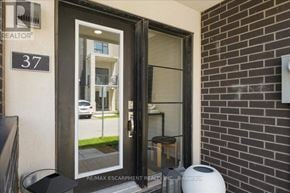 Burlington (Lasalle) townhouse for rent - A glass door with a reflection of a building and a sign that says RE/MAX Escarpment REALTY INC Brokerage.