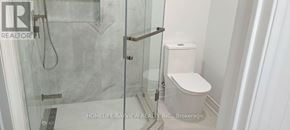 Bradford West Gwillimbury (Bradford) apartment for rent - A white toilet sits next to a glass shower stall in a bathroom.