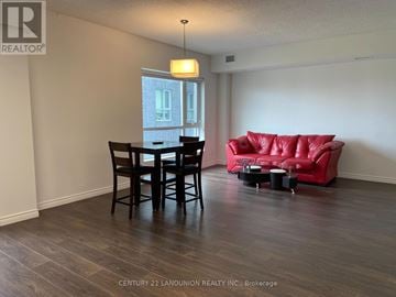 Waterloo condo for rent - A living room with a red couch and a dining table.