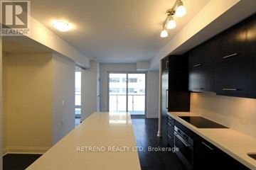 Toronto (Bay Street Corridor) condo for rent - A kitchen with black cabinets and a white countertop.