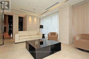 Toronto (Willowdale East) condo for rent - A modern living room with a glass coffee table and a white sofa.