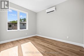 Ottawa apartment for rent - A room with a window showing a view of a house and a wall with a realtor logo.