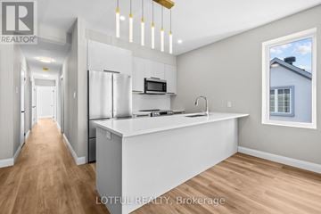 Ottawa apartment for rent - A modern kitchen with a white countertop and wooden flooring.