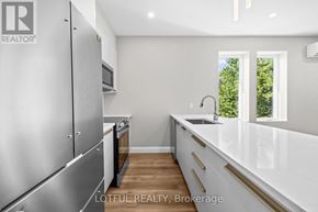 Ottawa apartment for rent - A modern kitchen with stainless steel appliances and white countertops.