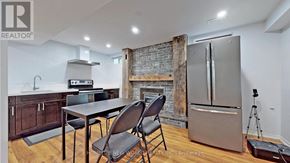 Mississauga (Erin Mills) apartment for rent - A kitchen with a table and chairs in front of a brick wall.