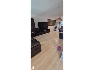 Edmonton apartment for rent - A living room with a black leather couch and a television.