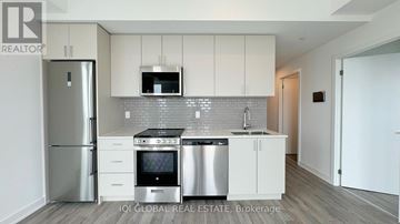 Oakville (Jm Joshua Meadows) condo for rent - A modern kitchen with white cabinets and stainless steel appliances.
