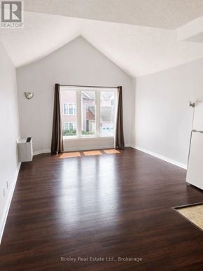Collingwood townhouse for rent - A room with wooden floors and a large window with a view of a building outside.