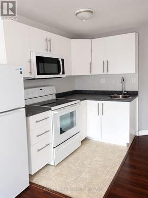 Collingwood townhouse for rent - A kitchen with white appliances and cabinets.