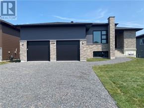 Azilda apartment for rent - A modern house with a gravel driveway in front.
