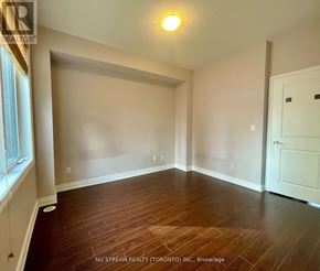 Markham (Commerce Valley) townhouse for rent - A room with wooden flooring and white walls.