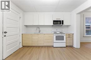 Brantford apartment for rent - A kitchen with white cabinets and a wooden floor.