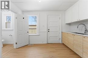 Brantford apartment for rent - A white room with wooden floors and a sink.