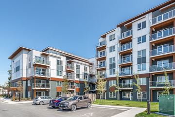Victora apartment for rent - A modern apartment building with cars parked in front.