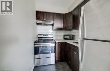 Cambridge townhouse for rent - A kitchen with a stove top oven and microwave above a counter.