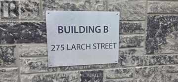 Waterloo condo for rent - A sign on a brick wall that says Building B 275 Larch Street.