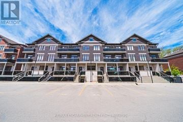 Burlington (Brant) townhouse for rent - A large apartment complex with multiple balconies and a clear blue sky above.