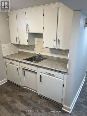 Brampton (Downtown Brampton) multi-family for rent - A kitchen with white cabinets and a granite countertop.