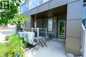 Waterdown townhouse for rent - A patio with a table and chairs is in front of a modern building.