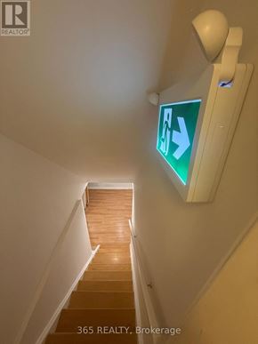 Milton (Cl Clarke) apartment for rent - A stairway with a green exit sign on the wall.