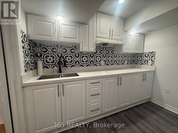Milton (Cl Clarke) apartment for rent - A kitchen with white cabinets and a black and white backsplash.