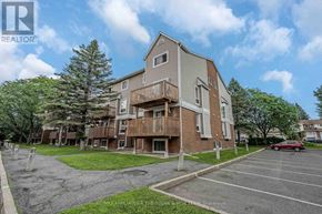 Ottawa townhouse for rent - A large apartment complex with a parking lot in front.
