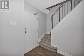 Ottawa townhouse for rent - A staircase with a white door and a light switch on the wall.