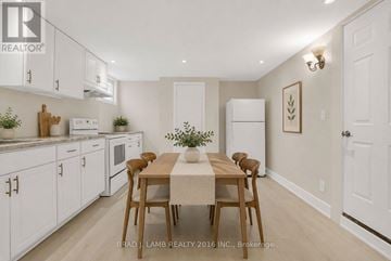 Barrie (Allandale Heights) apartment for rent - A kitchen with white cabinets and a dining table with chairs.