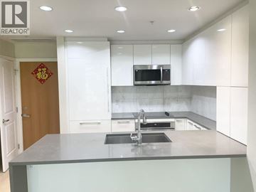 Vancouver apartment for rent - A modern kitchen with a grey countertop and white cabinets.