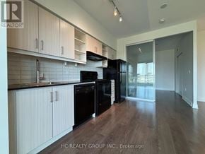 Toronto (Thorncliffe Park) condo for rent - A kitchen with black appliances and white cabinets.