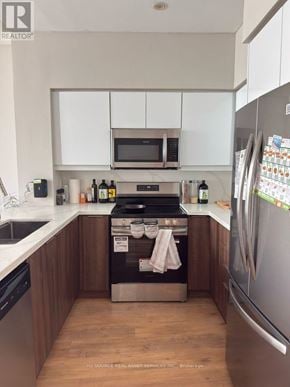 Toronto (Willowdale West) condo for rent - A kitchen with a refrigerator, sink, and cabinets.
