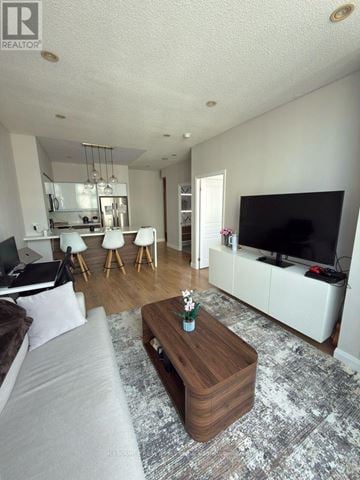 Toronto (Willowdale West) condo for rent - A living room with a grey couch and a wooden coffee table.