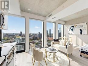 Toronto (Moss Park) condo for rent - A modern living room with a view of the city skyline.