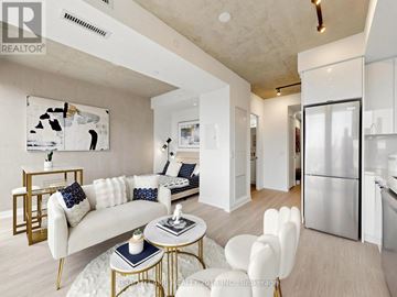 Toronto (Moss Park) condo for rent - A modern living room with a white sofa and a coffee table.