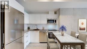 Toronto (Moss Park) condo for rent - A modern kitchen with a refrigerator, microwave, oven, and sink.