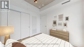 Toronto (Moss Park) condo for rent - A bedroom with a bed, nightstand, and a lamp.