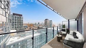 Toronto (Moss Park) condo for rent - A balcony with a table and chairs overlooking a cityscape.