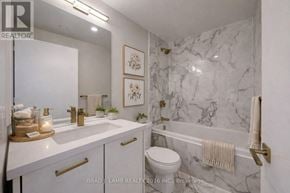 Toronto (Moss Park) condo for rent - A white bathroom with a marble wall and a towel hanging on the towel rack.