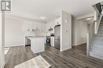 Ottawa townhouse for rent - A kitchen with white cabinets and a wooden floor.